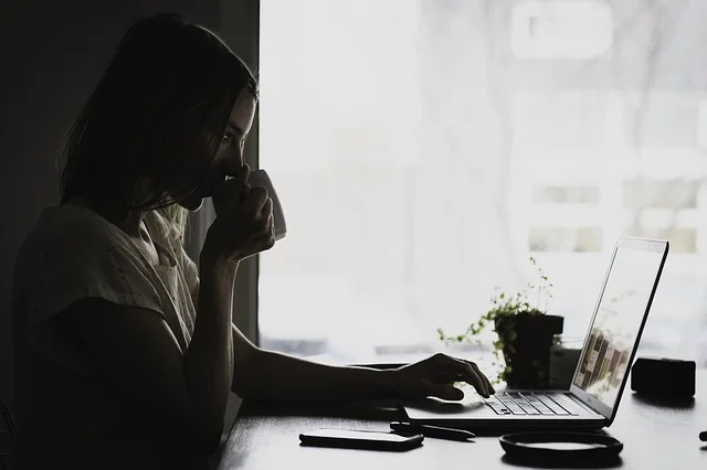 Woman doing research on laptop with coffee