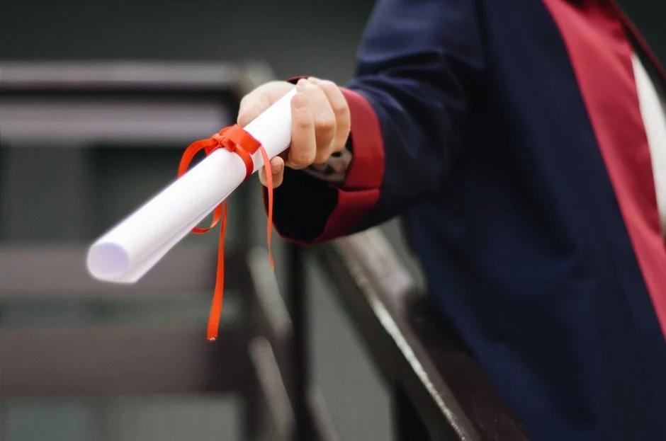 Hand holding Diploma scroll.