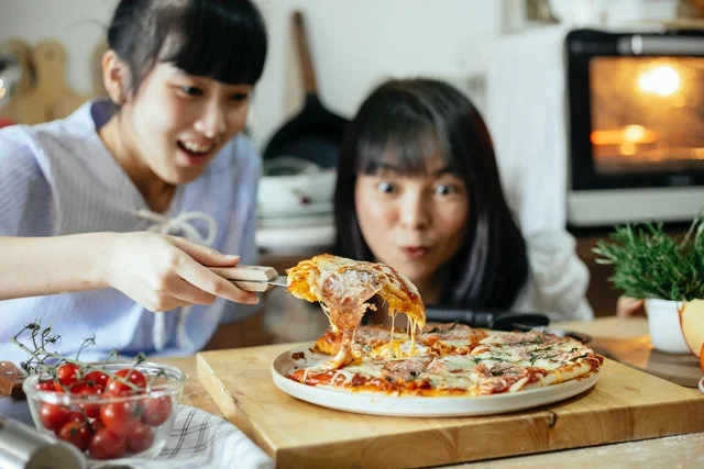 Students eating pizza they made in their dorm.