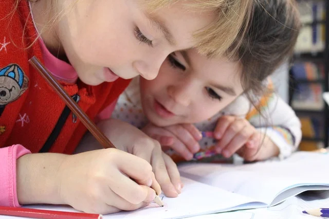 Little girl holding a pencil.