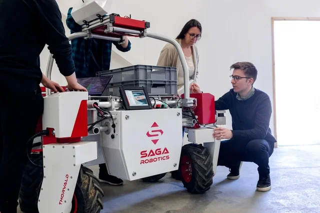 Male and female mechanical engineers working on a robot.