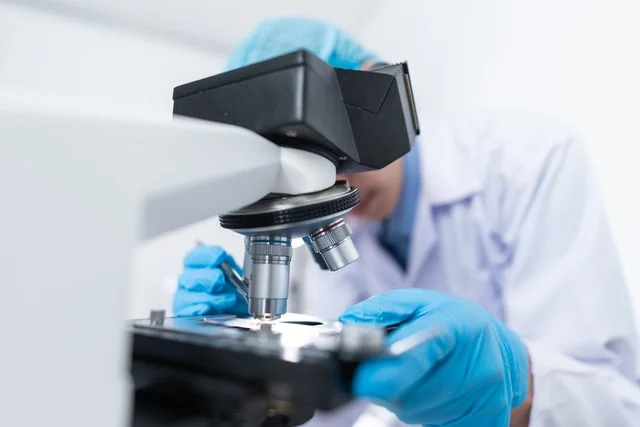 Scientist using microscope.