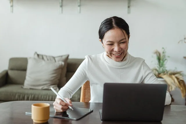 Lady using laptop and ipad.