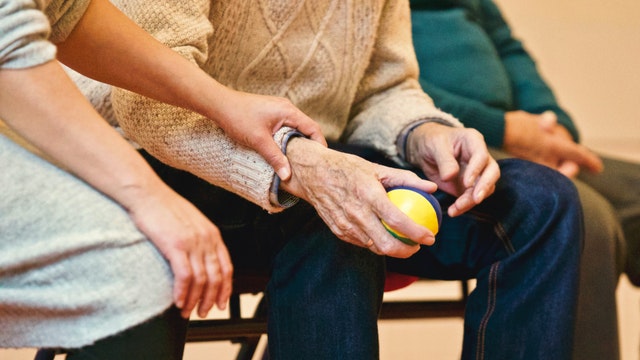 Elderly holding a ball at the rehabilitation centre.