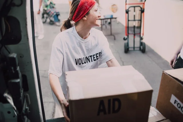 Female volunteer moving boxes after SPM.