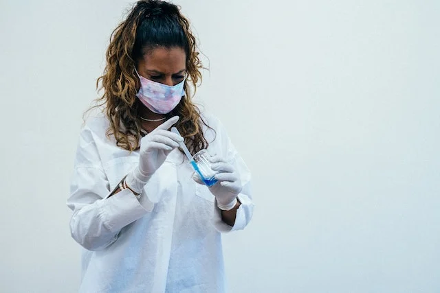 Chemical engineer extracting liquid using syringe.