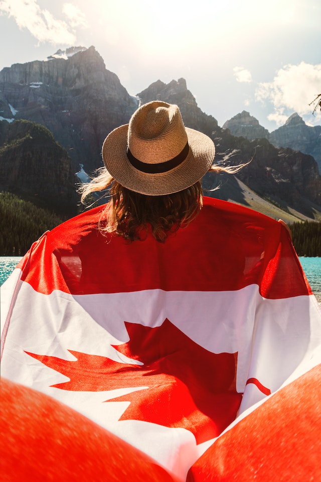 Honours degree student holding Canada flag.
