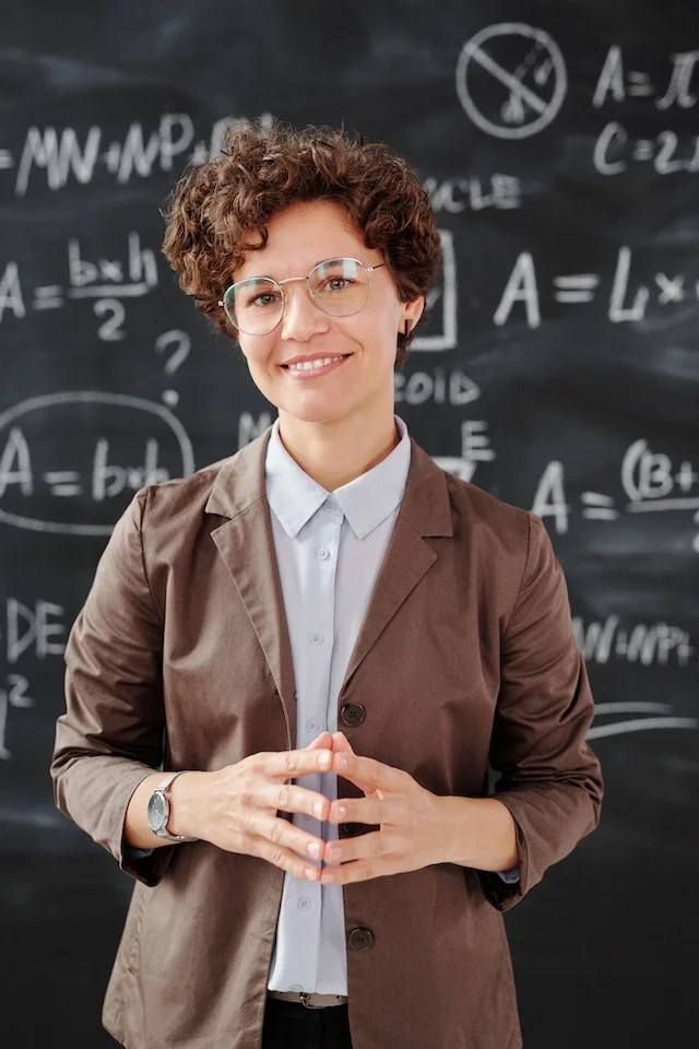 A teacher smiling in class.